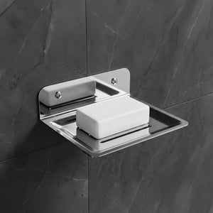 Metallic soap dish with a bar of soap on a dark tiled wall